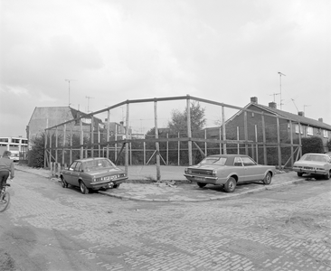 882114 Gezicht op het braakliggende terrein, omgeven door een hekwerk op de hoek van de Hoveniersstraat (rechts) en de ...
